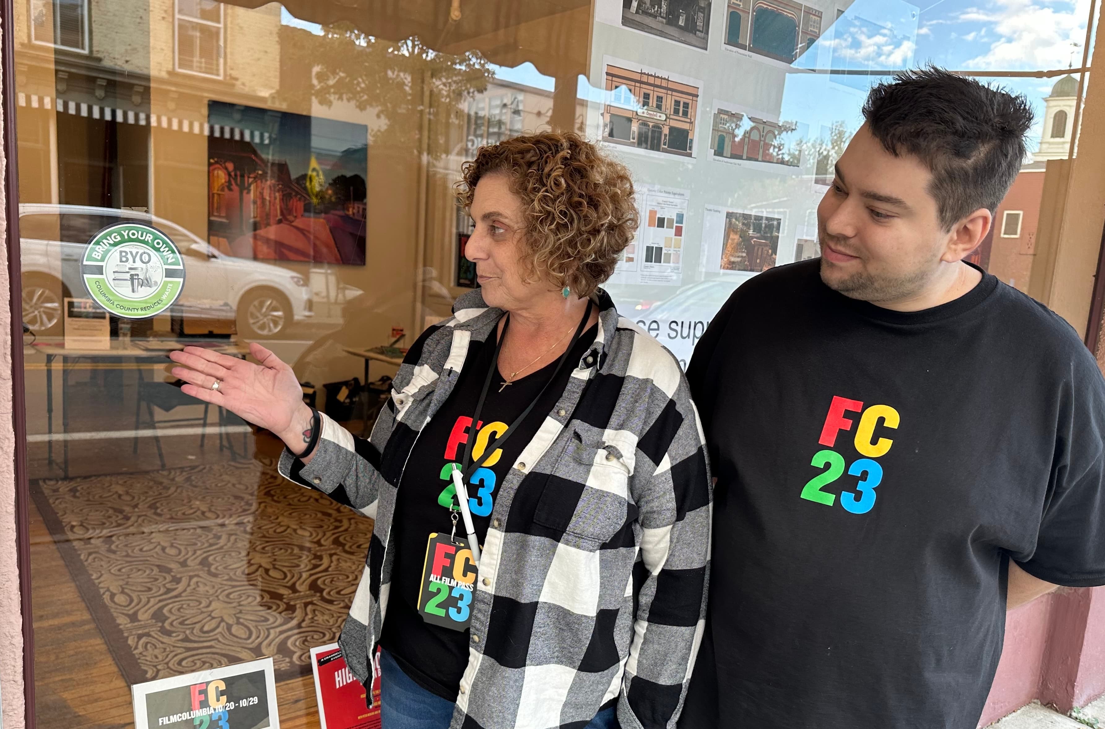 Dawn Steward outside the Crandell Theatre pointing at a BYO program sticker.