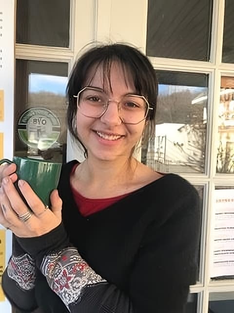 Eve Hindes, Manager of Our Daily Bread in Chatham, NY, holding a reusable container.